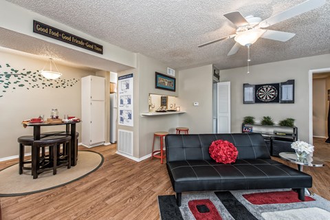 a living room with a couch and a table and a ceiling fan